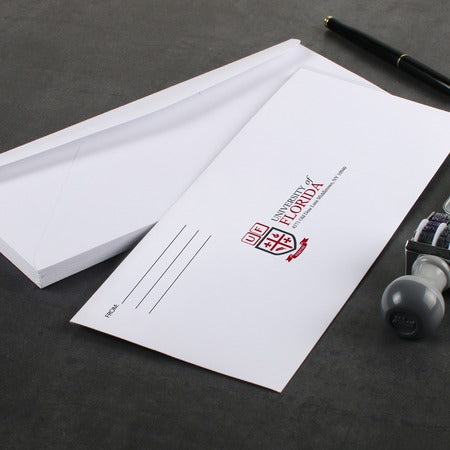 #9 full color printed envelope on desk with pen and date stamp.