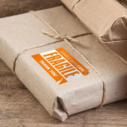"Fragile" orange vinyl sticker on parcel.